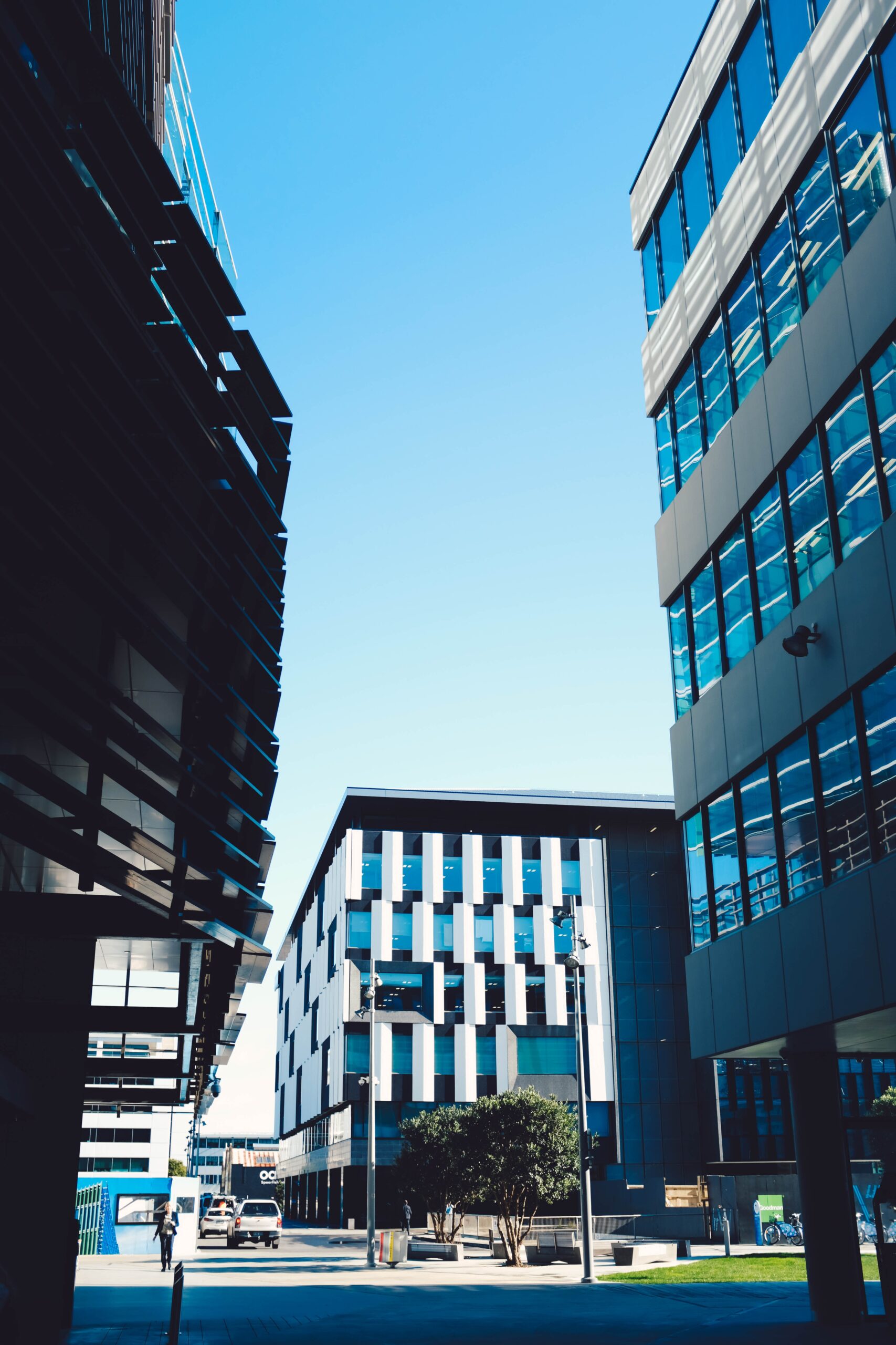 Picture Modern Skyscrapers With Blue Windows Parking Area Blue Sky Scaled
